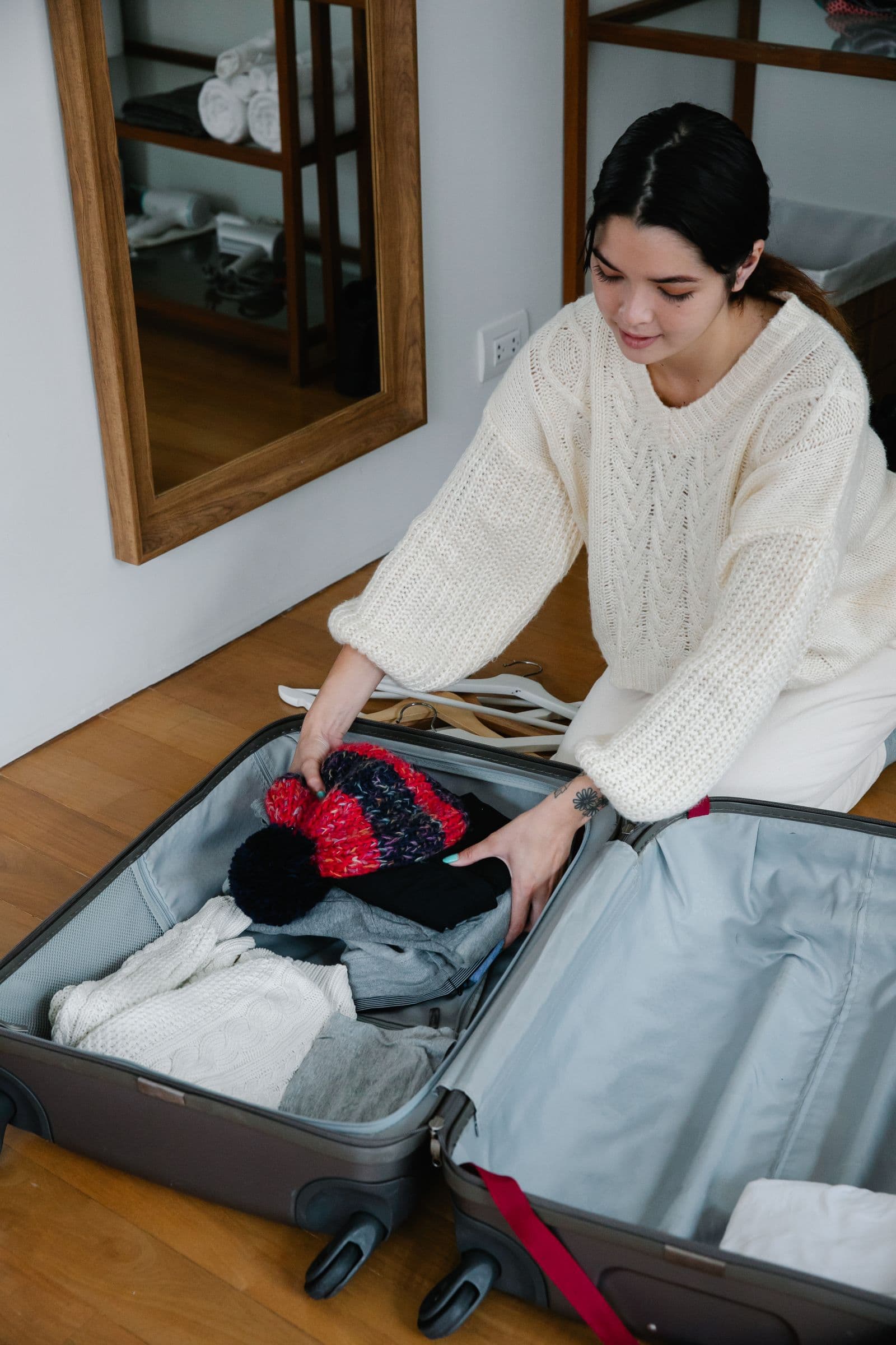 Woman arranging clothes in an open suitcase