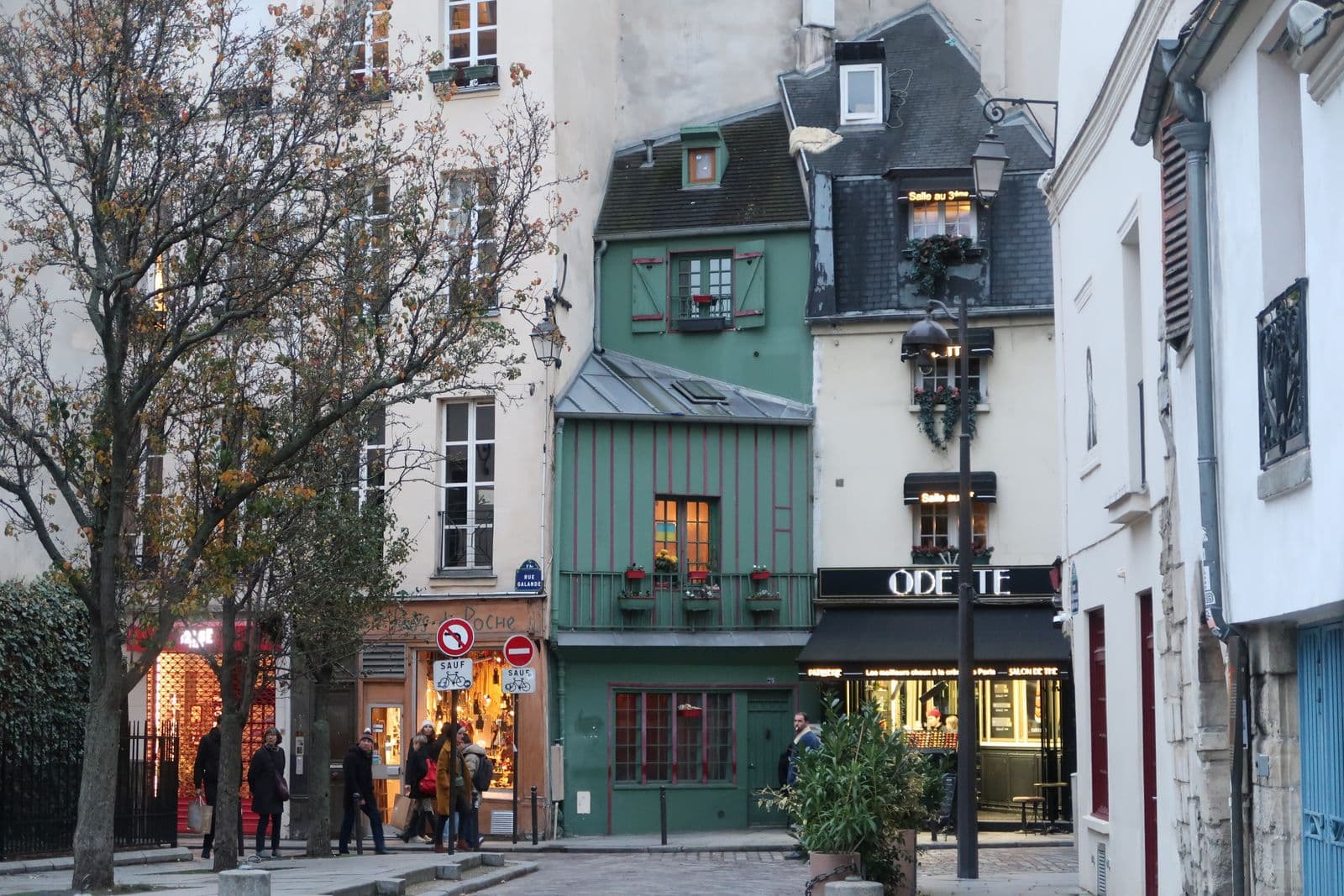 People in light coats walking on a Paris street in spring