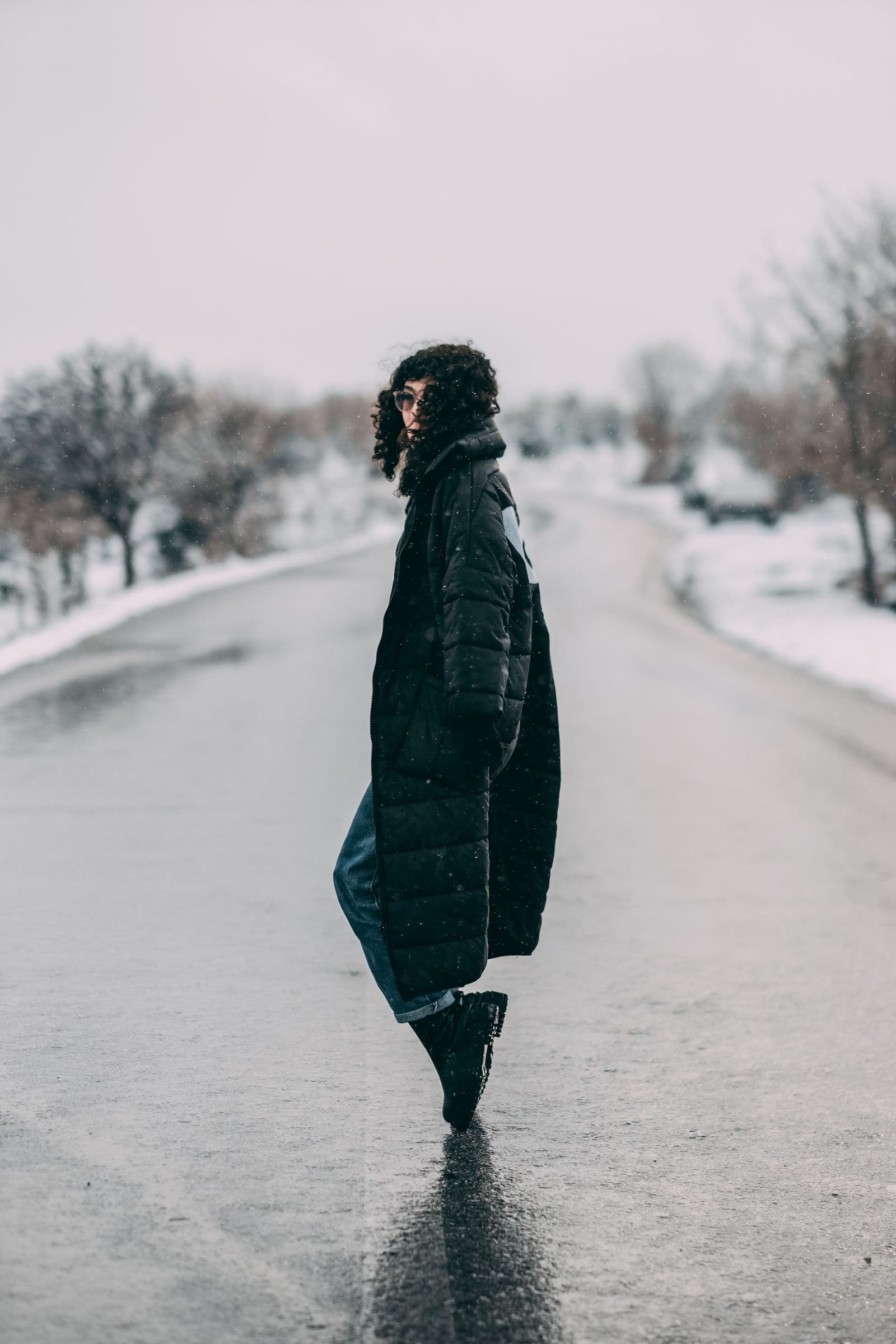 Woman in a black winter coat walking on a city street