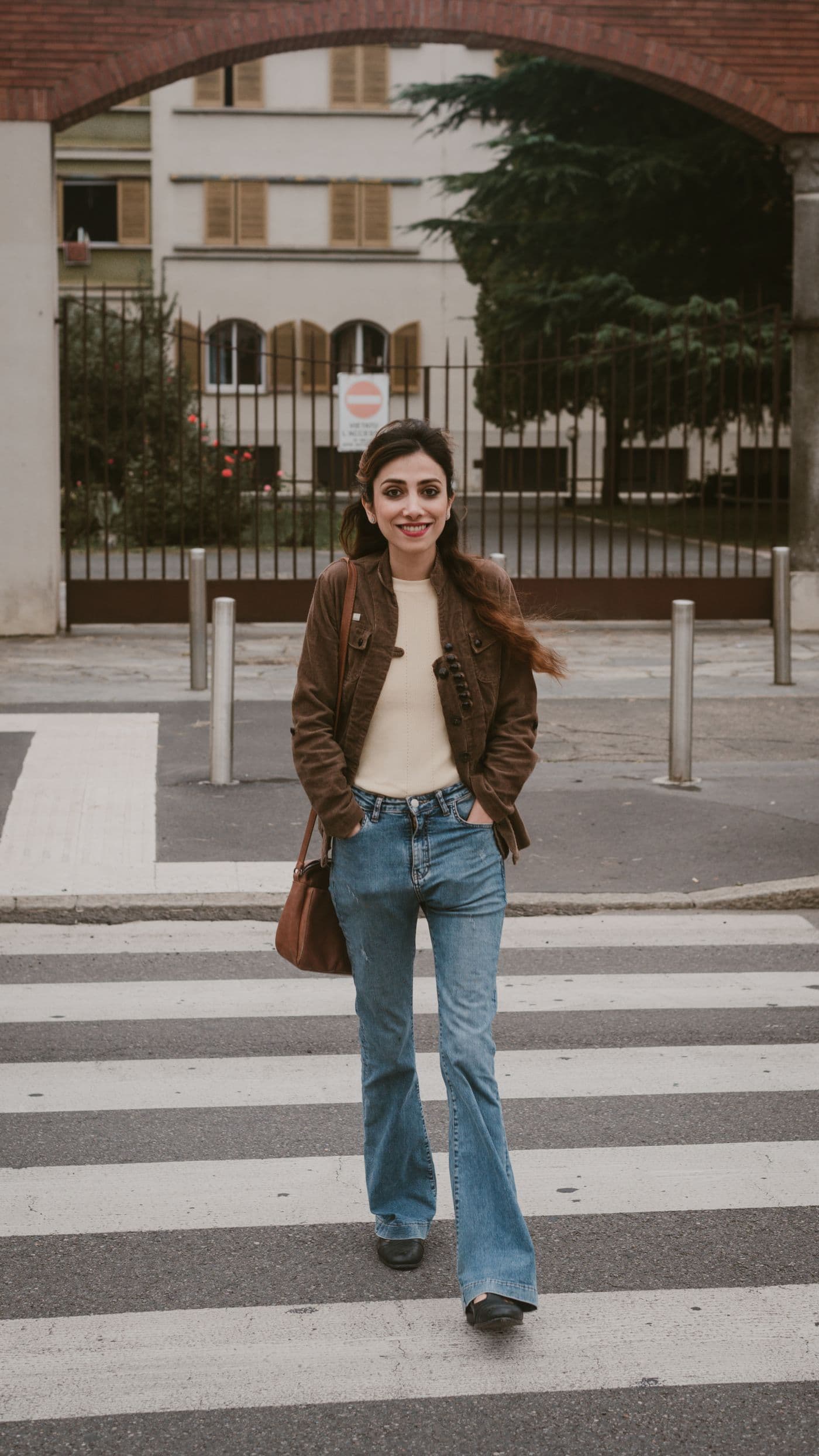 Woman in a relaxed city outfit crossing a sunny street