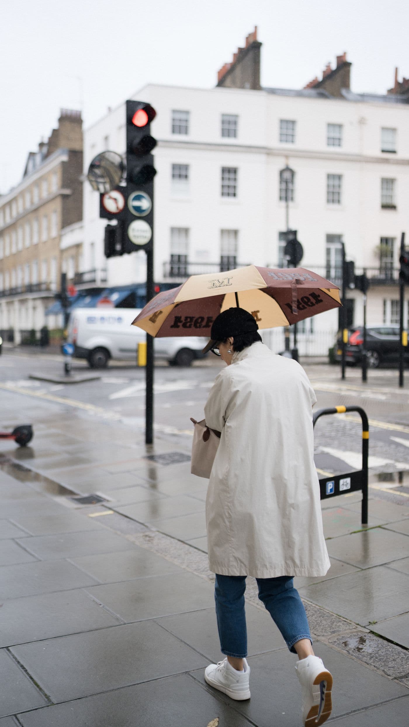 Woman walking with an umbrella on a rainy city street