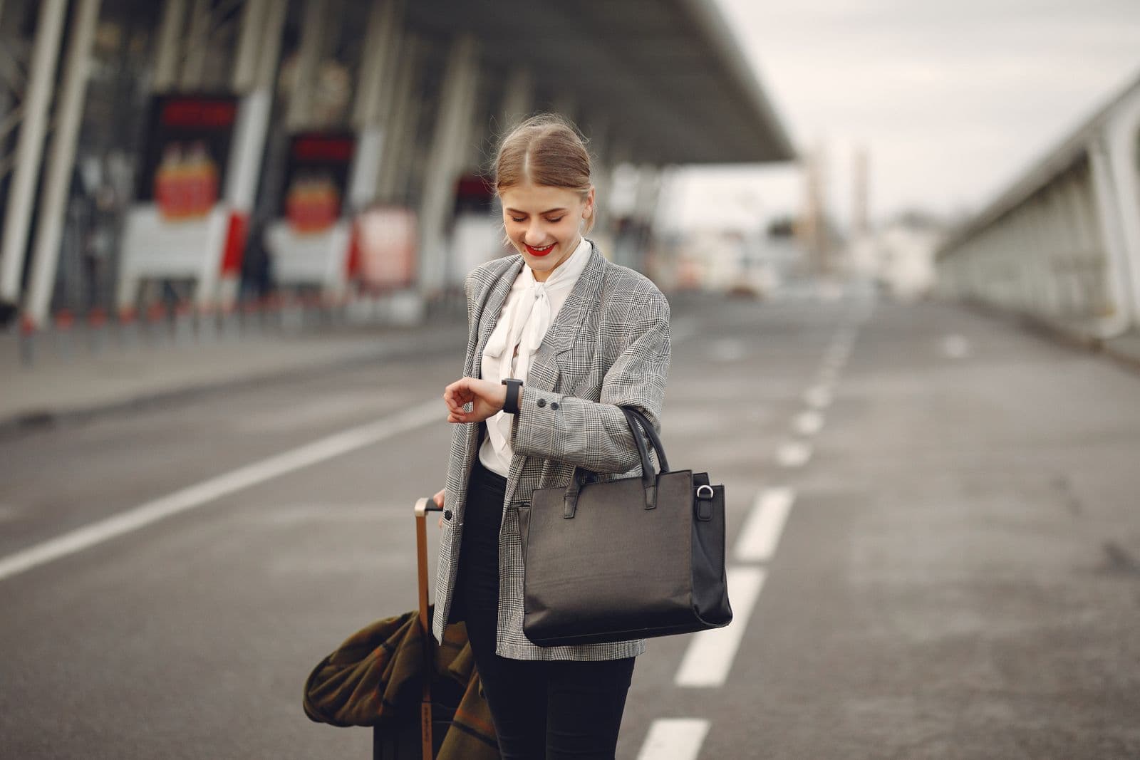 Professional woman traveling with a suitcase and handbag