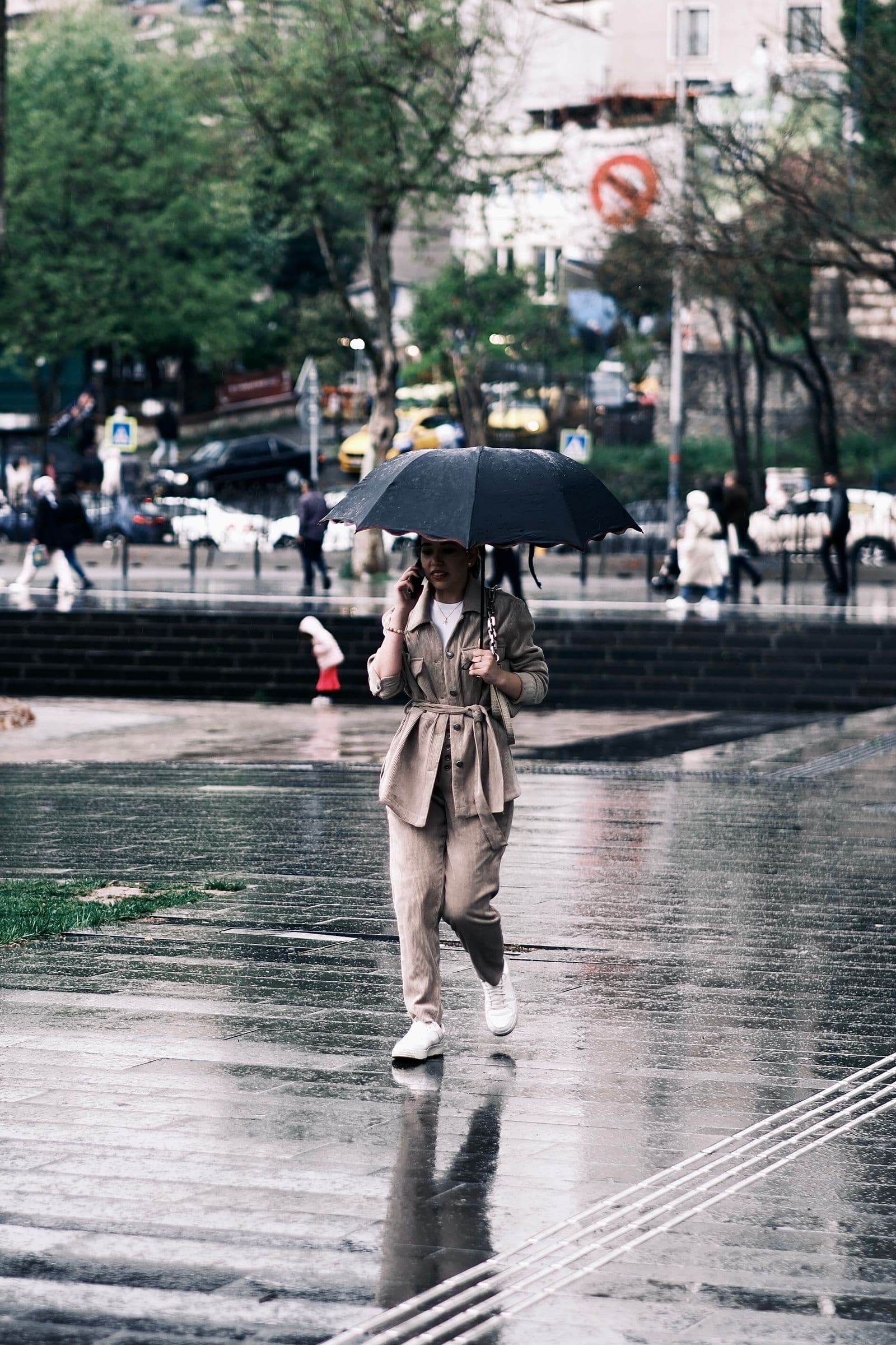 Woman walking with an umbrella in windy city weather