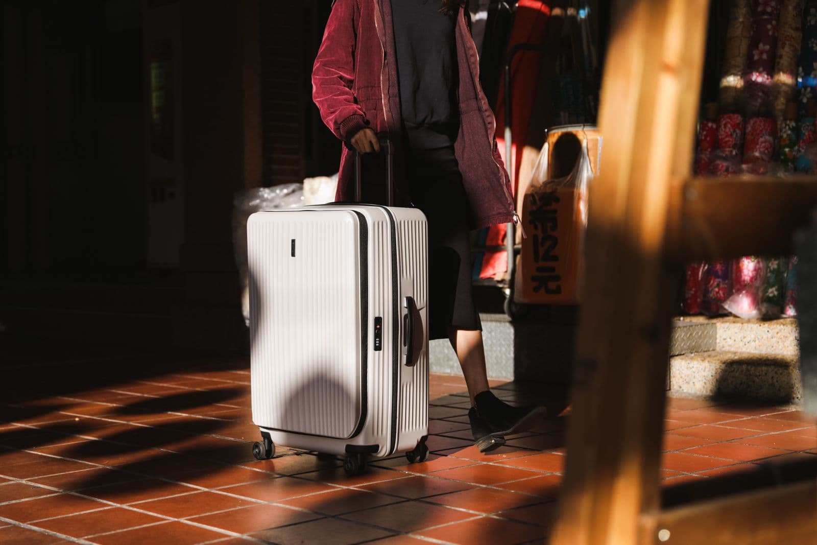 Woman walking with a suitcase in a practical travel outfit