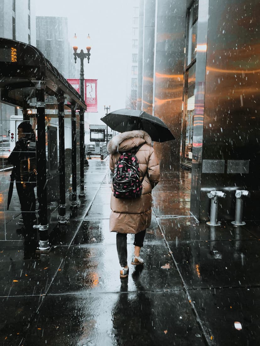 Woman walking beneath an umbrella on a London street