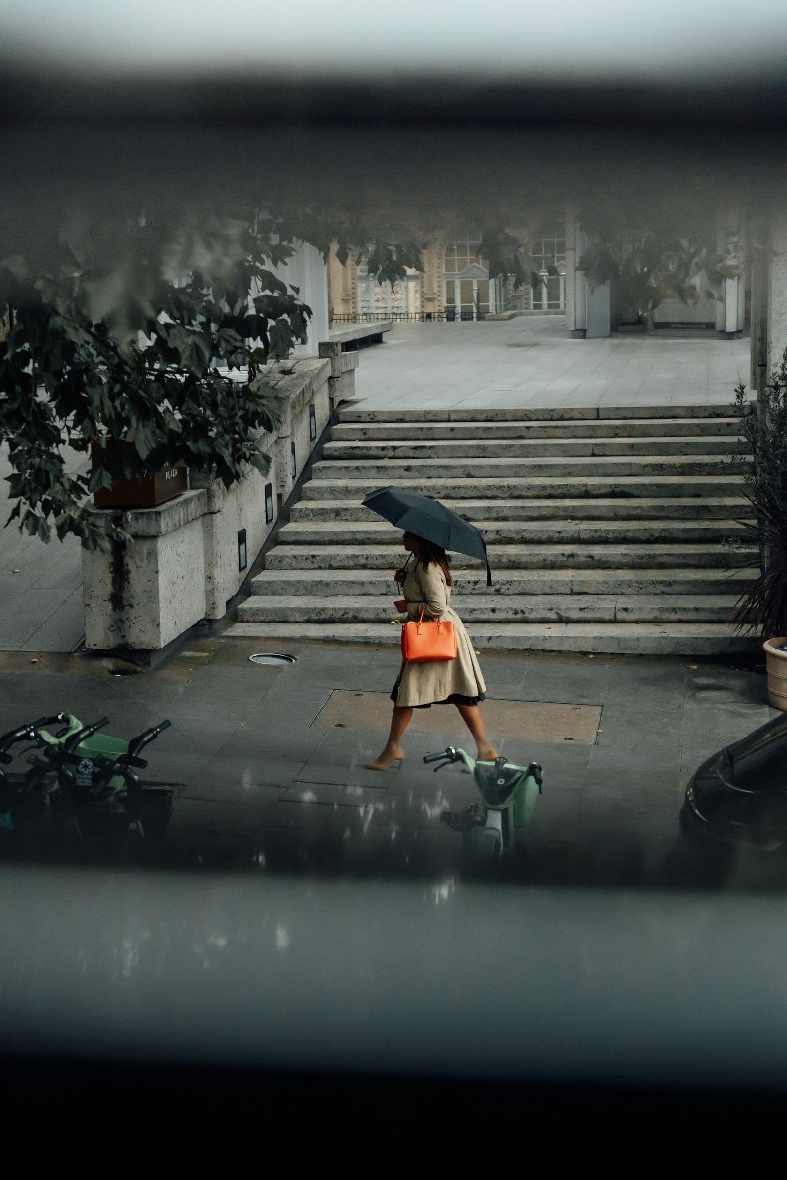 Woman carrying an umbrella on a wet London street